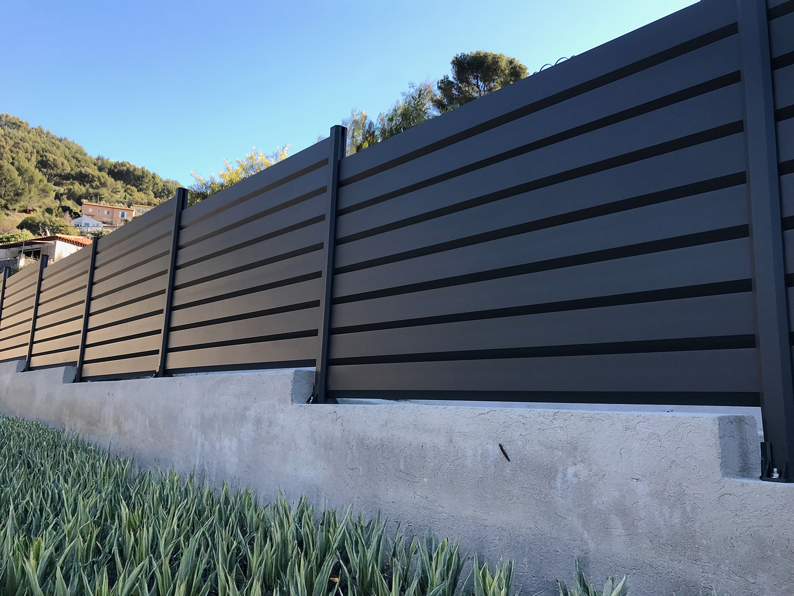 Clôture aluminium gris quartz sur muret paysager