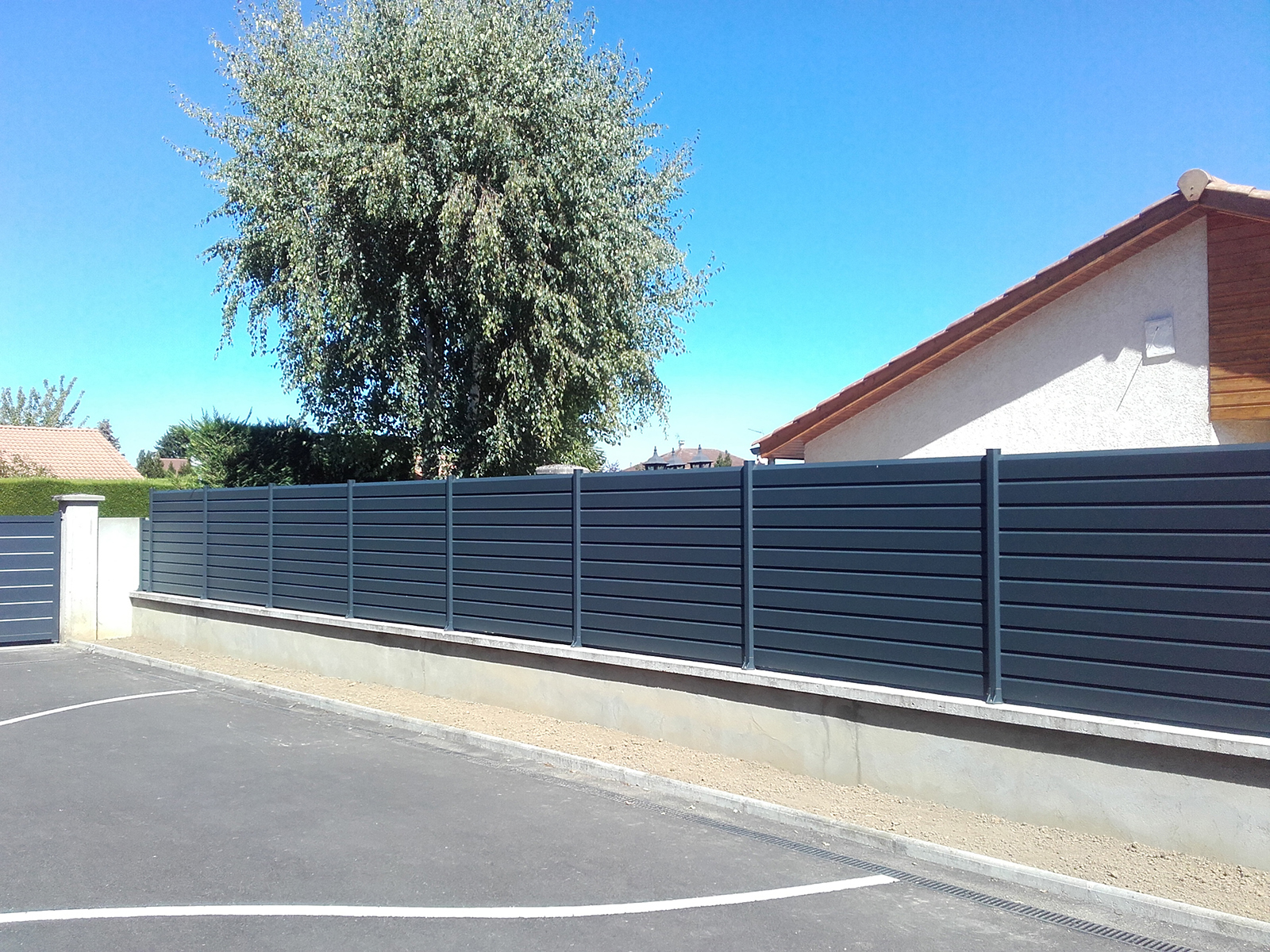Clôture aluminium gris quartz sur muret paysager